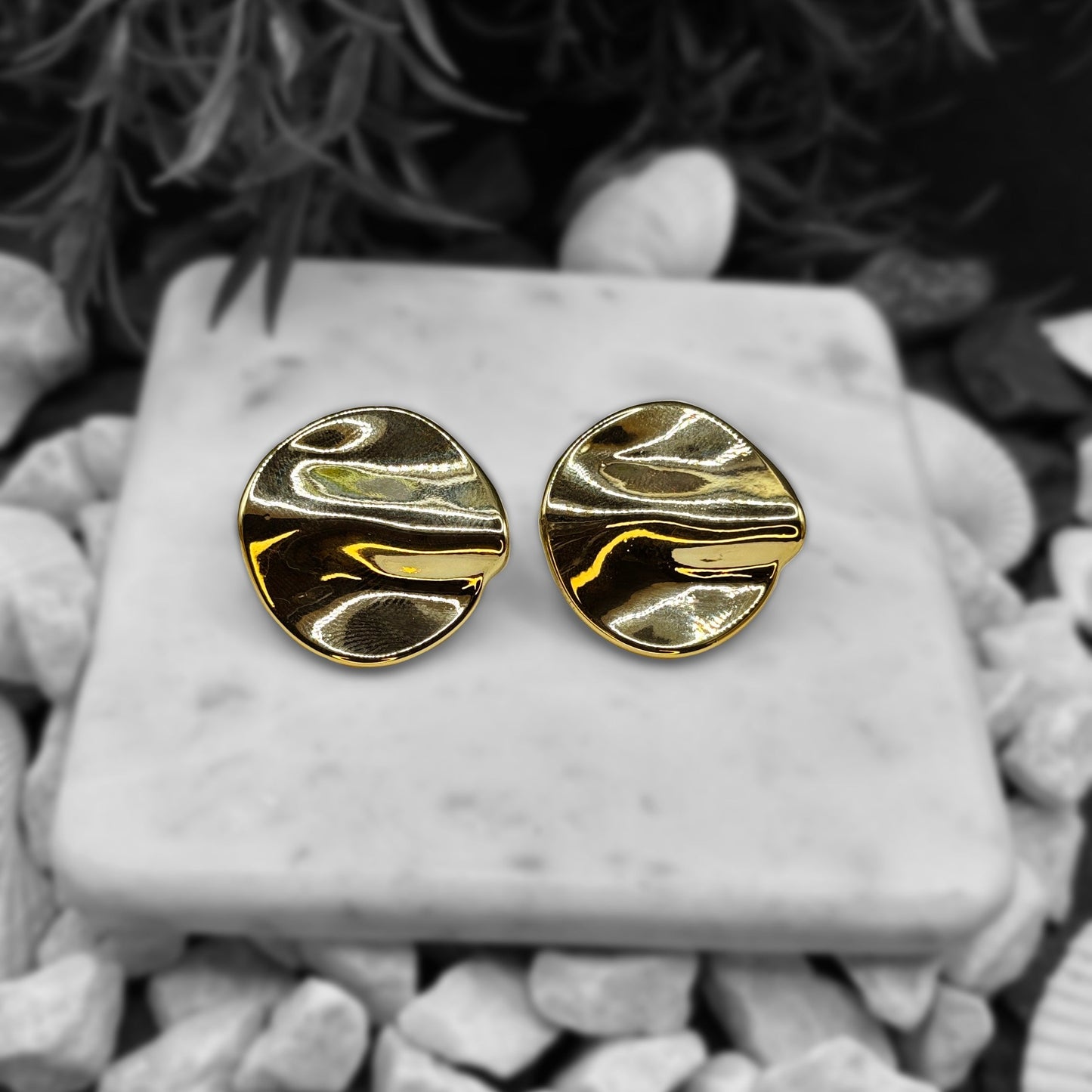 Earrings resembling pearls on a marble slab