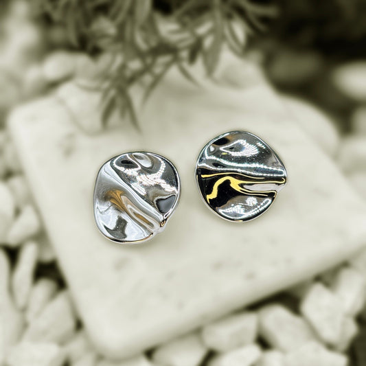Earrings resembling pearls on a marble slab